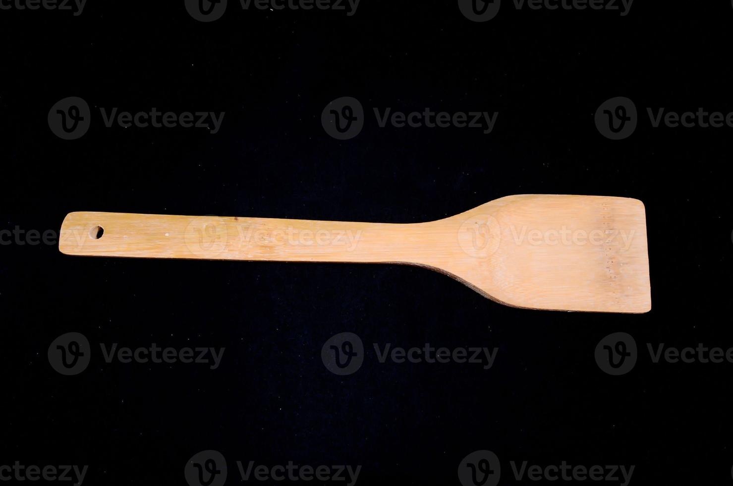 Wooden spoon on black background photo
