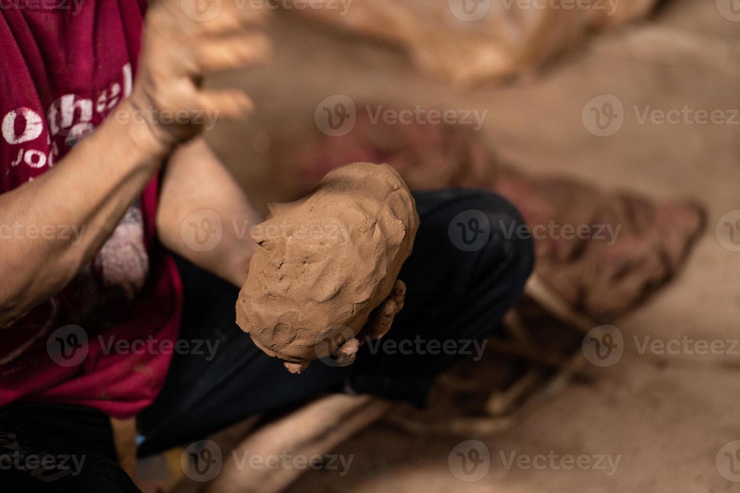 Craftsmen are preparing clay dough for making pottery photo