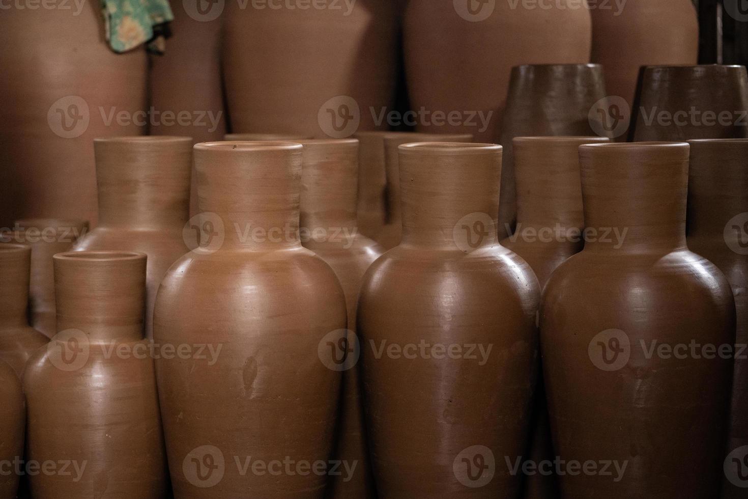 Rows of pottery crafts that are still new, and are still in the process of being made. photo