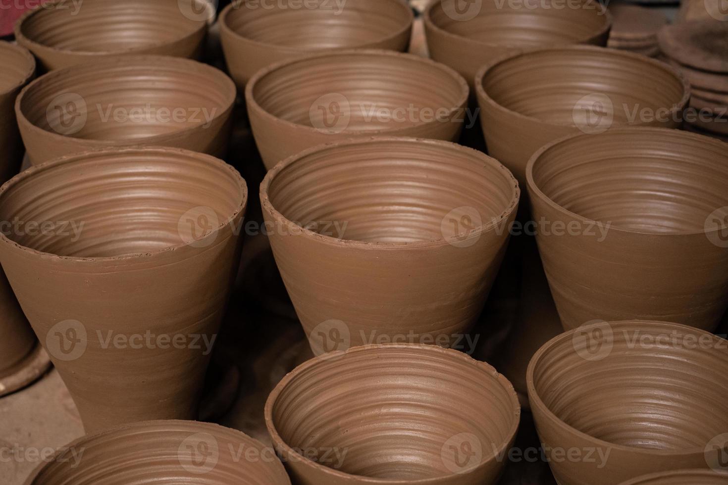 Rows of pottery crafts that are still new, and are still in the process of being made. photo