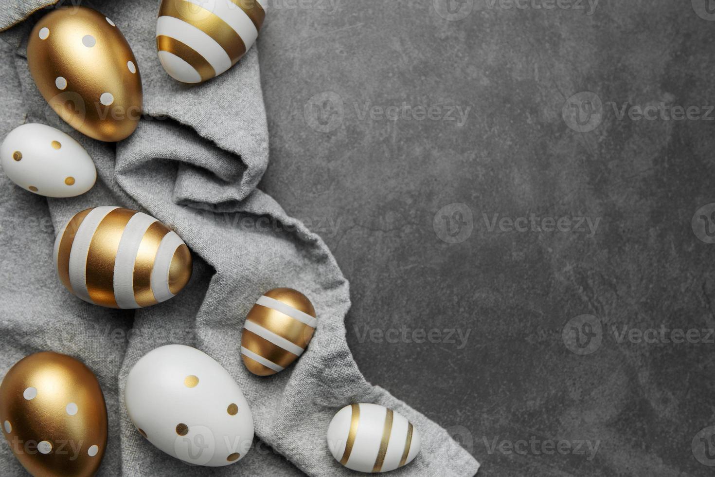 los huevos de pascua están pintados con pintura dorada sobre un fondo de lino gris. foto