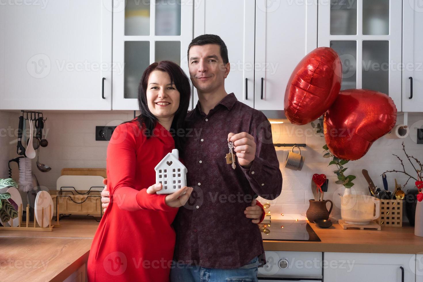 Man and woman in love date at home in kitchen with keys of house. Valentine's Day, happy couple, love story. Love nest, mortgage, relocation, purchase, real estate, housing for young family photo