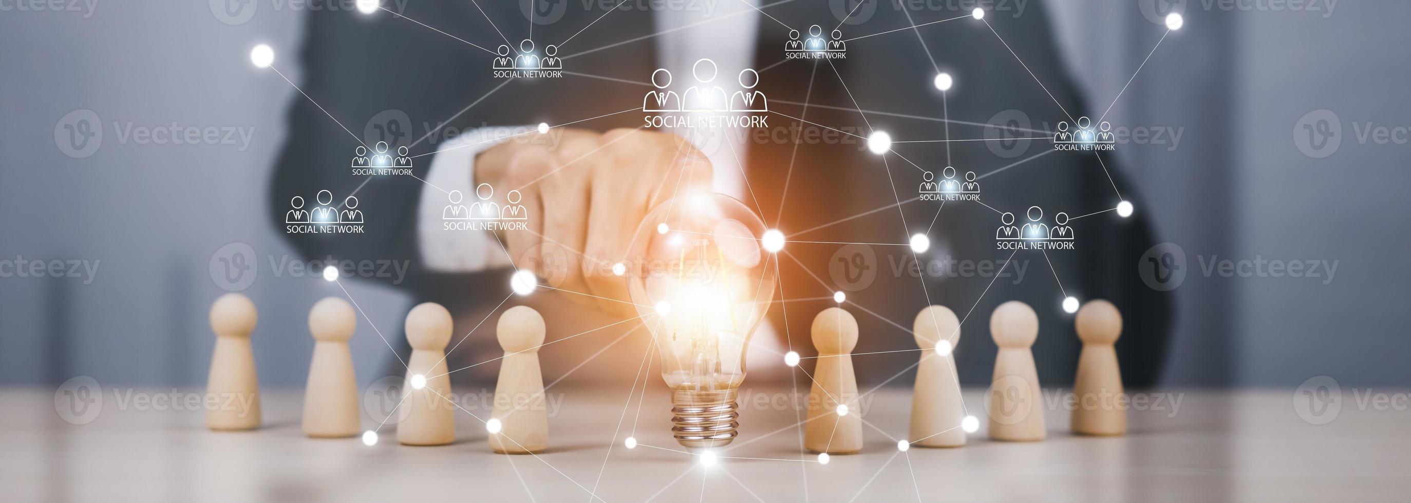 thinking and creative, Businessman hand holding light bulb on the wooden people, Teamwork and idea concept, Successful team leader, Businessman hand choose people standing out from the crowd. photo