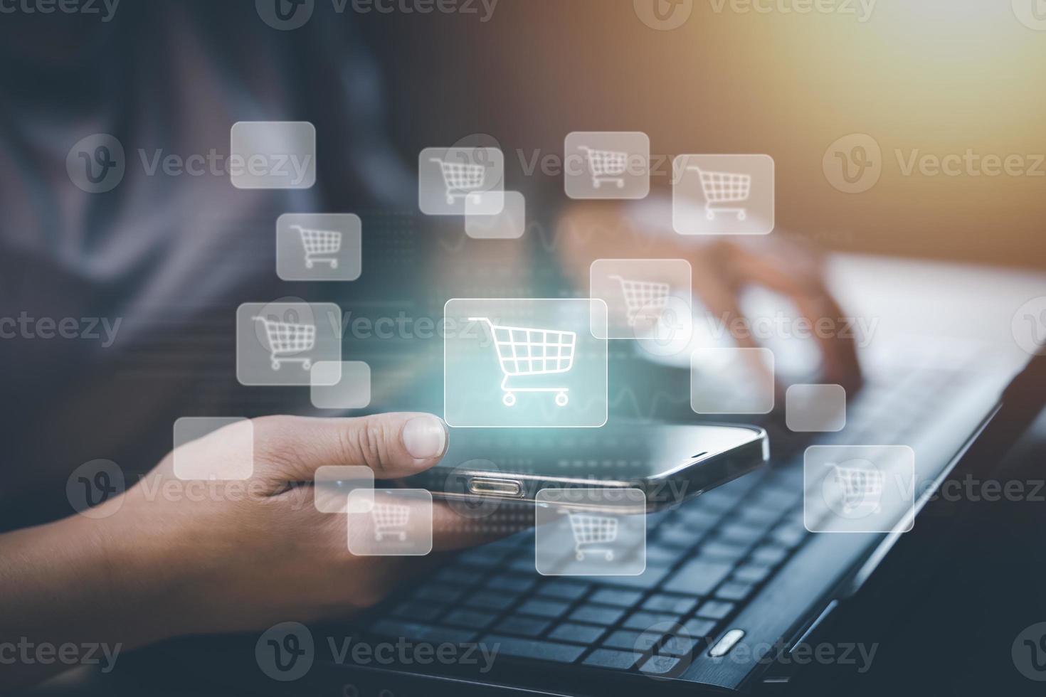 Hand hold smartphone with  typing on keyboard with online shopping concept, Shopping cart part of the network in hand, Innovation in e-Commerce, Online shopping business with selecting shopping cart. photo