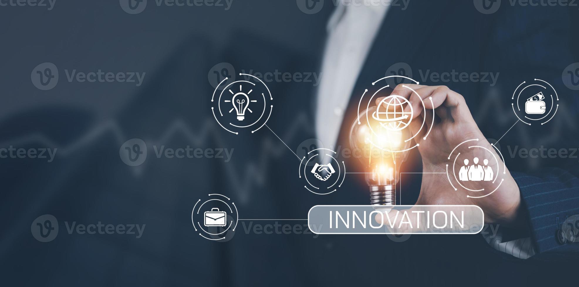 Businessman hand holding light bulb with icons and working on the desk, Creativity and innovation are keys to success.Concept of new idea and innovation with energy and power , working at home, photo