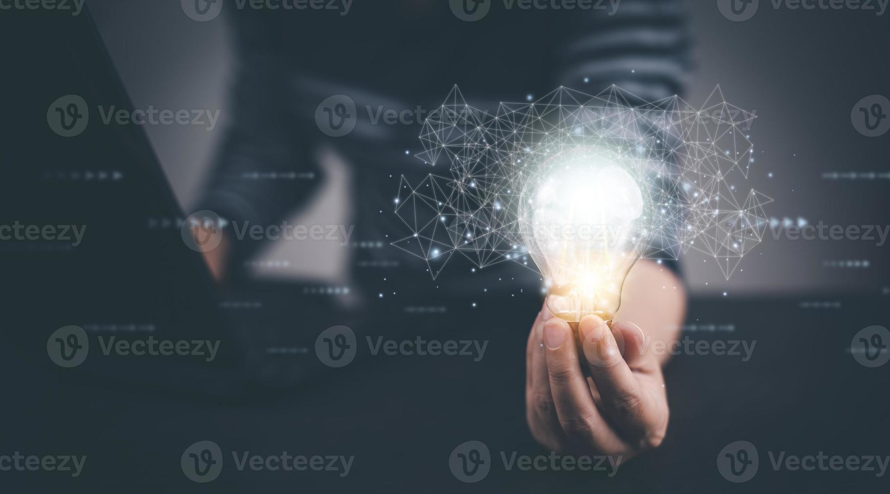 Businessman hand holding light bulb with icons and working on the desk, Creativity and innovation are keys to success.Concept of new idea and innovation with energy and power , working at home, photo