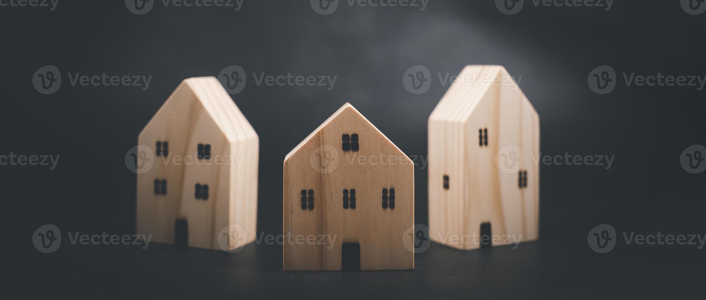 Concept idea Wooden house models on the table, Simulated wooden house on white background Housing business ideas, Toy house made of wood placed on a black background with copy space, Miniature houses photo