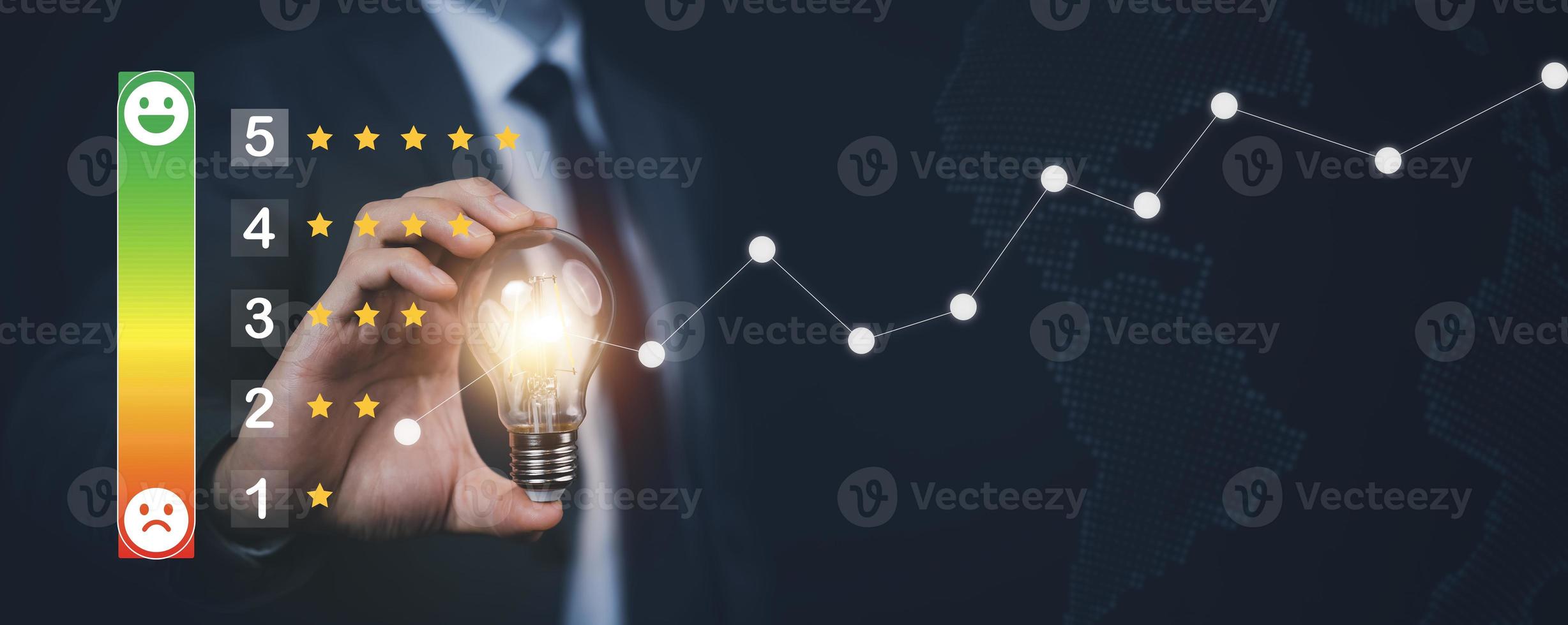 Businessman holding glowing light bulb with Customer review satisfaction feedback survey concept, service experience on online application, service leading to reputation ranking of business. photo