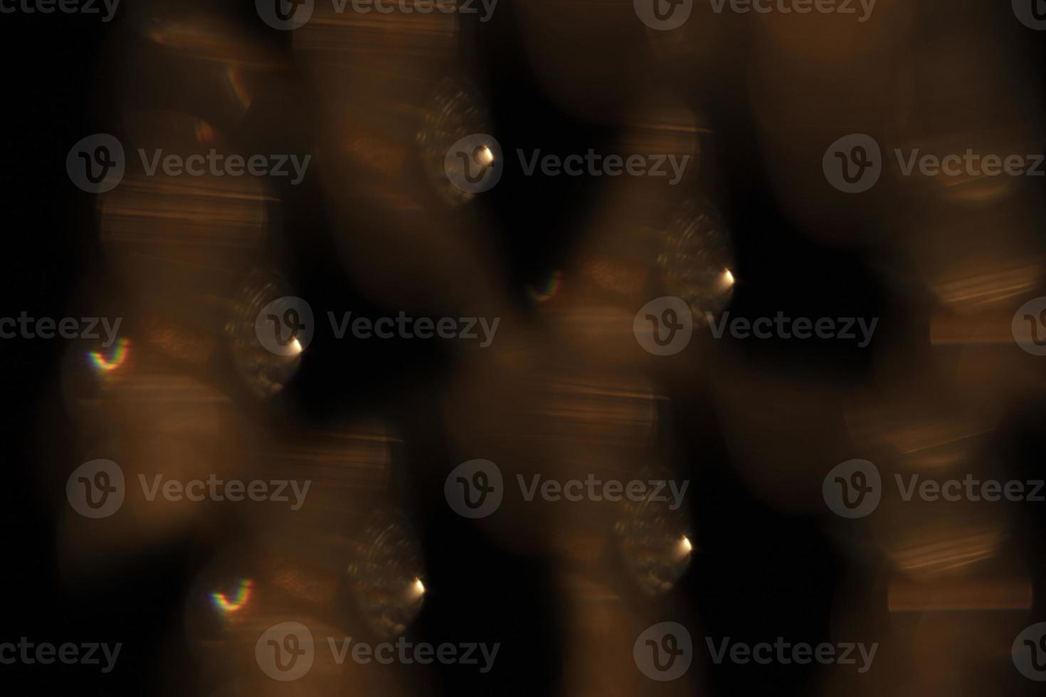 The effect of golden highlights on a black background. Optical glass glare for use in screen mode. Abstract background, flashing iridescent. photo