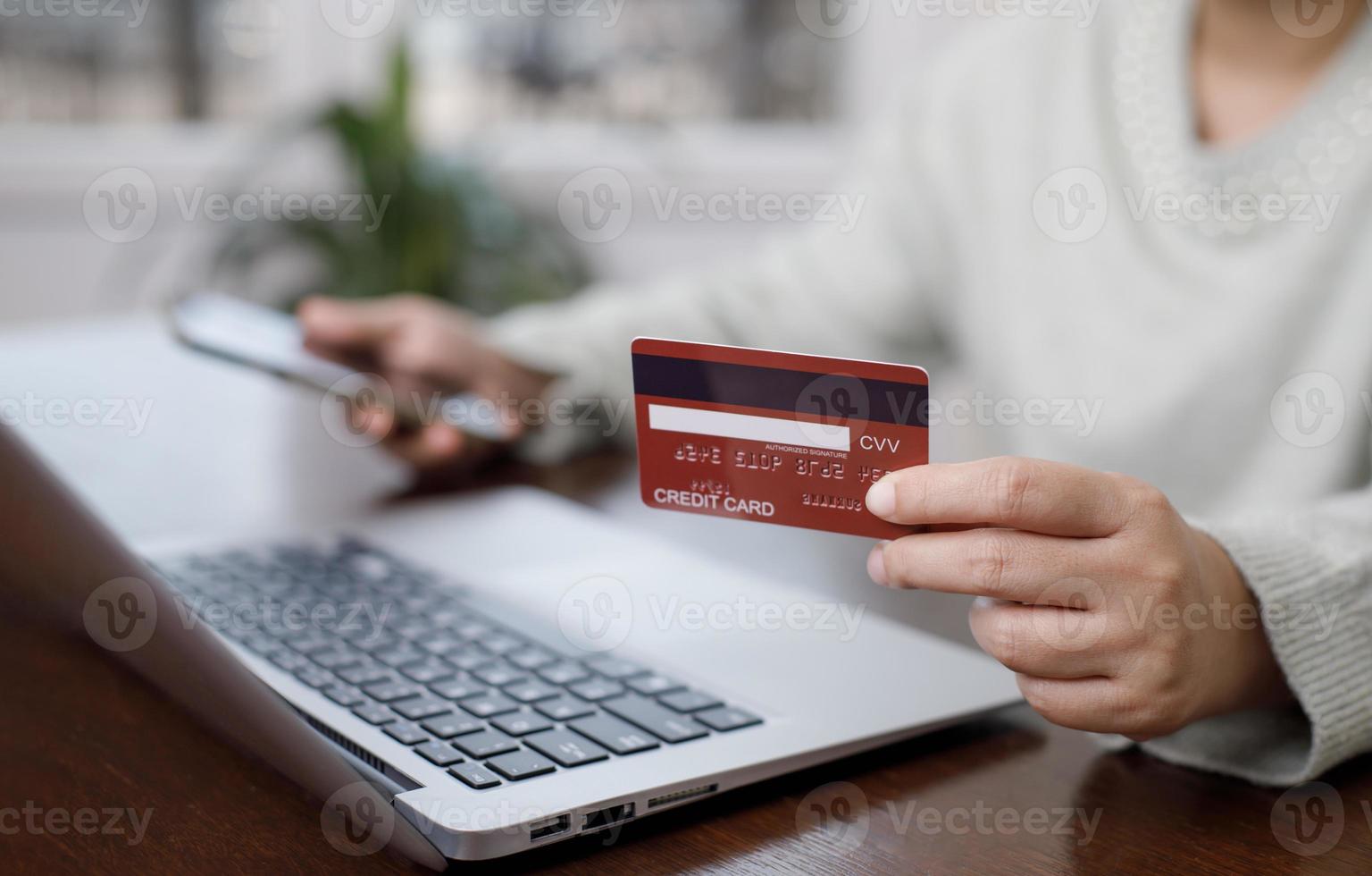 Woman holding credit card for makes a purchase on the Internet on the laptop computer with credit card, online payment, shopping online, e-commerce, internet banking, spending money concept. photo