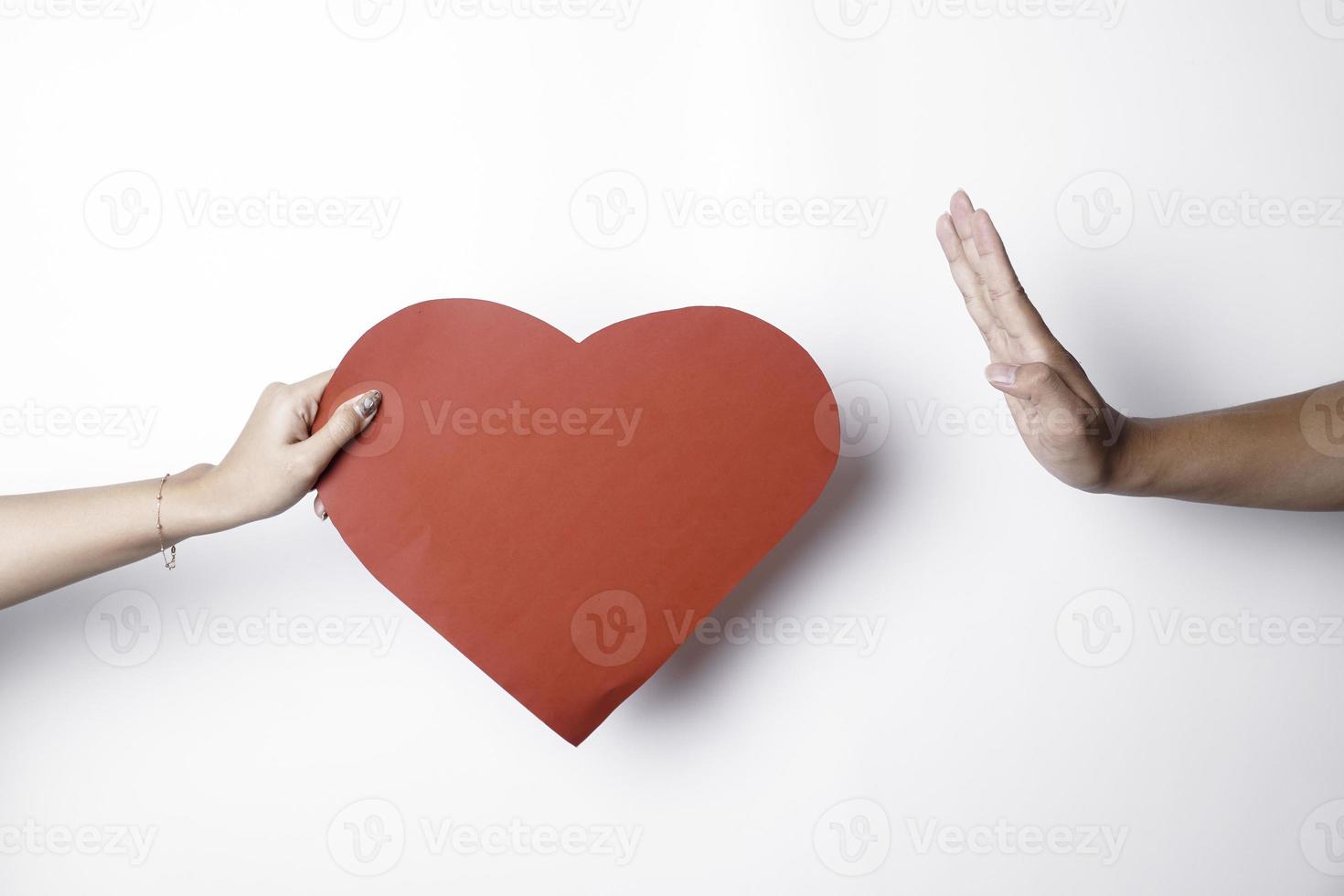 A photo of a heart being denied by someone, isolated on white background. Unrequited love concept.