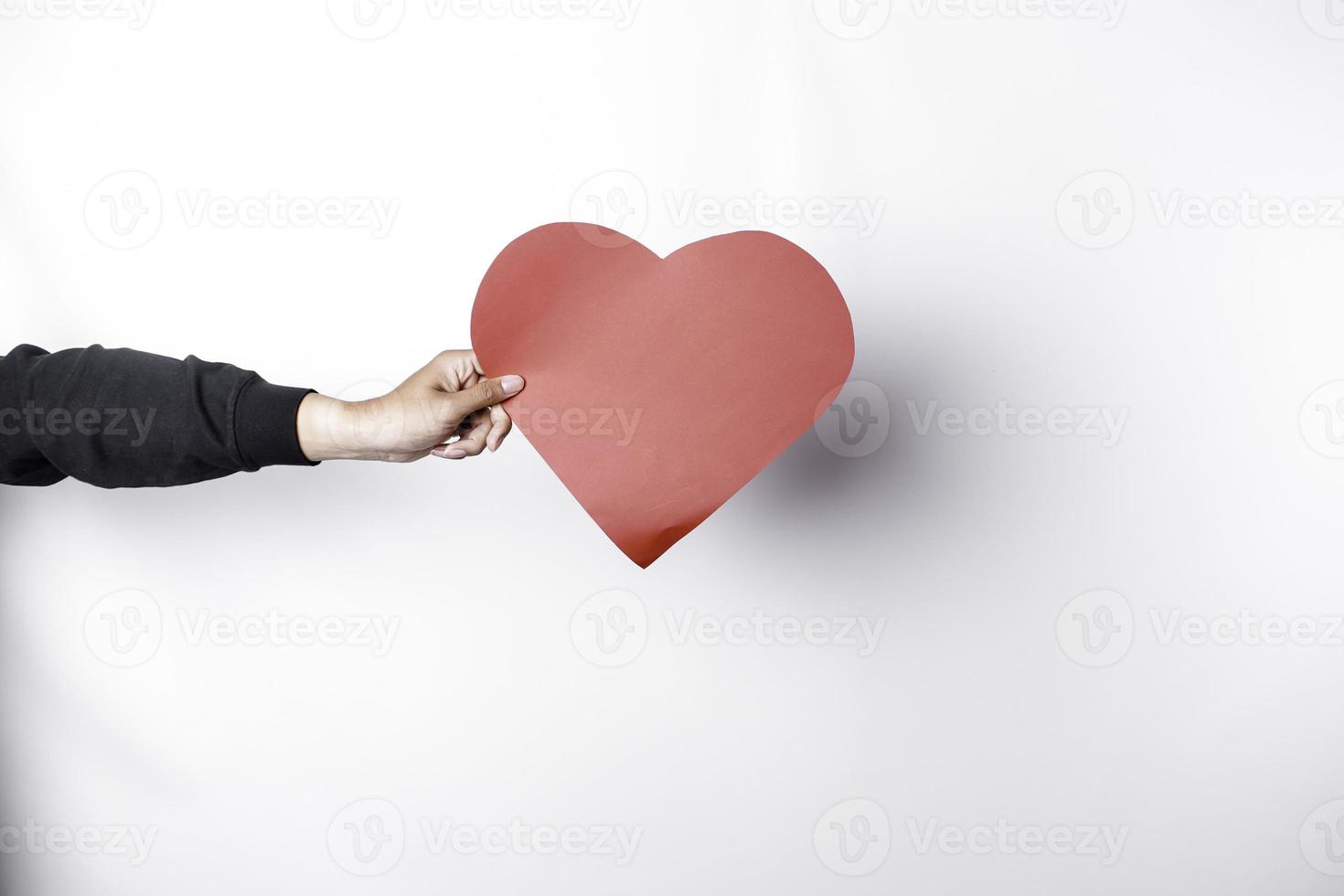 una foto de un papel en forma de corazón rojo aislado sobre fondo blanco.