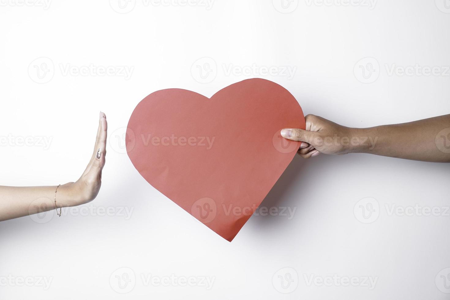 A photo of a heart being denied by someone, isolated on white background. Unrequited love concept.