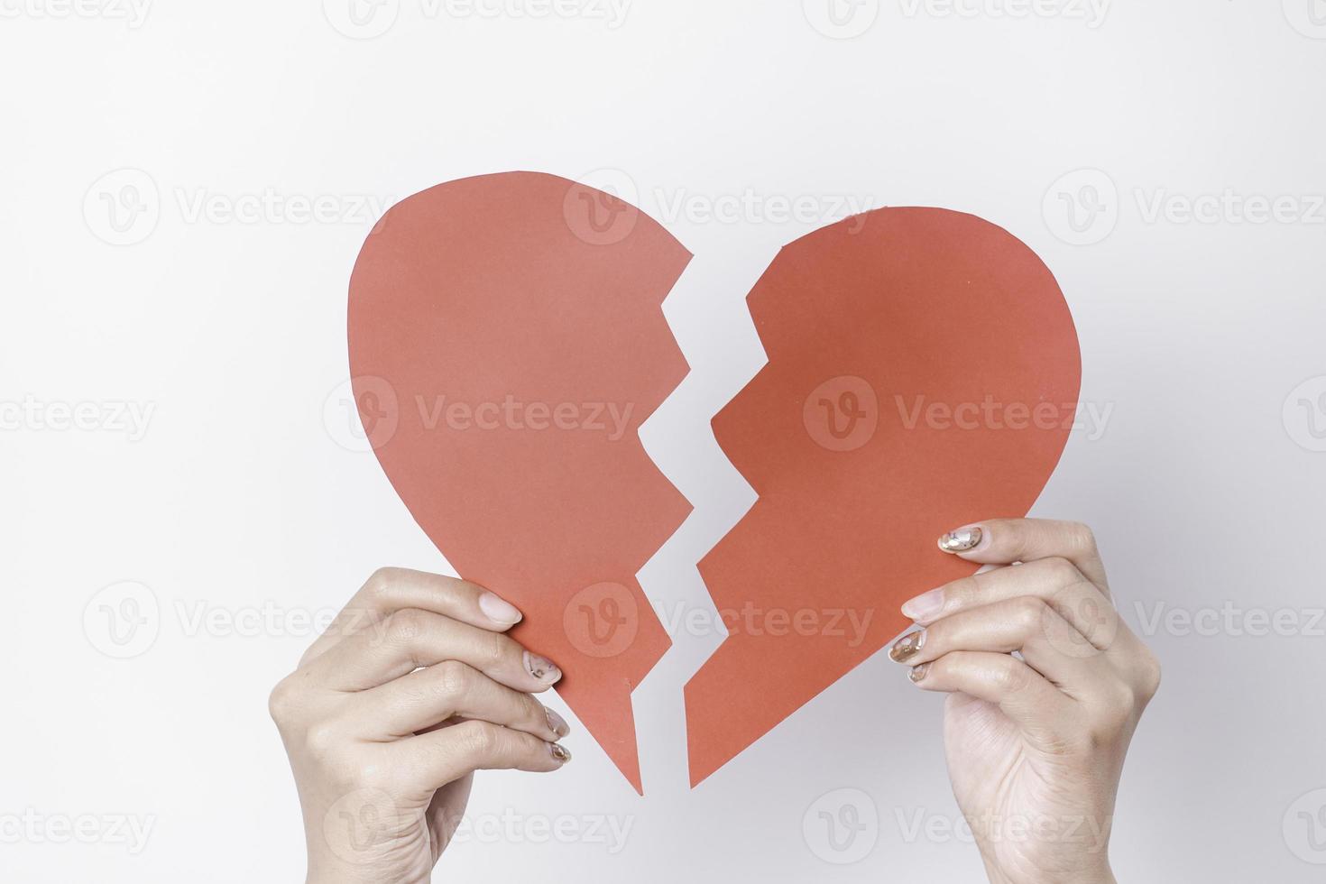 Close up of paper broken heart isolated on white background photo