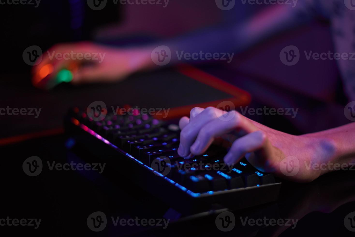 Gamer play computer game, use rgb neon colored keyboard photo