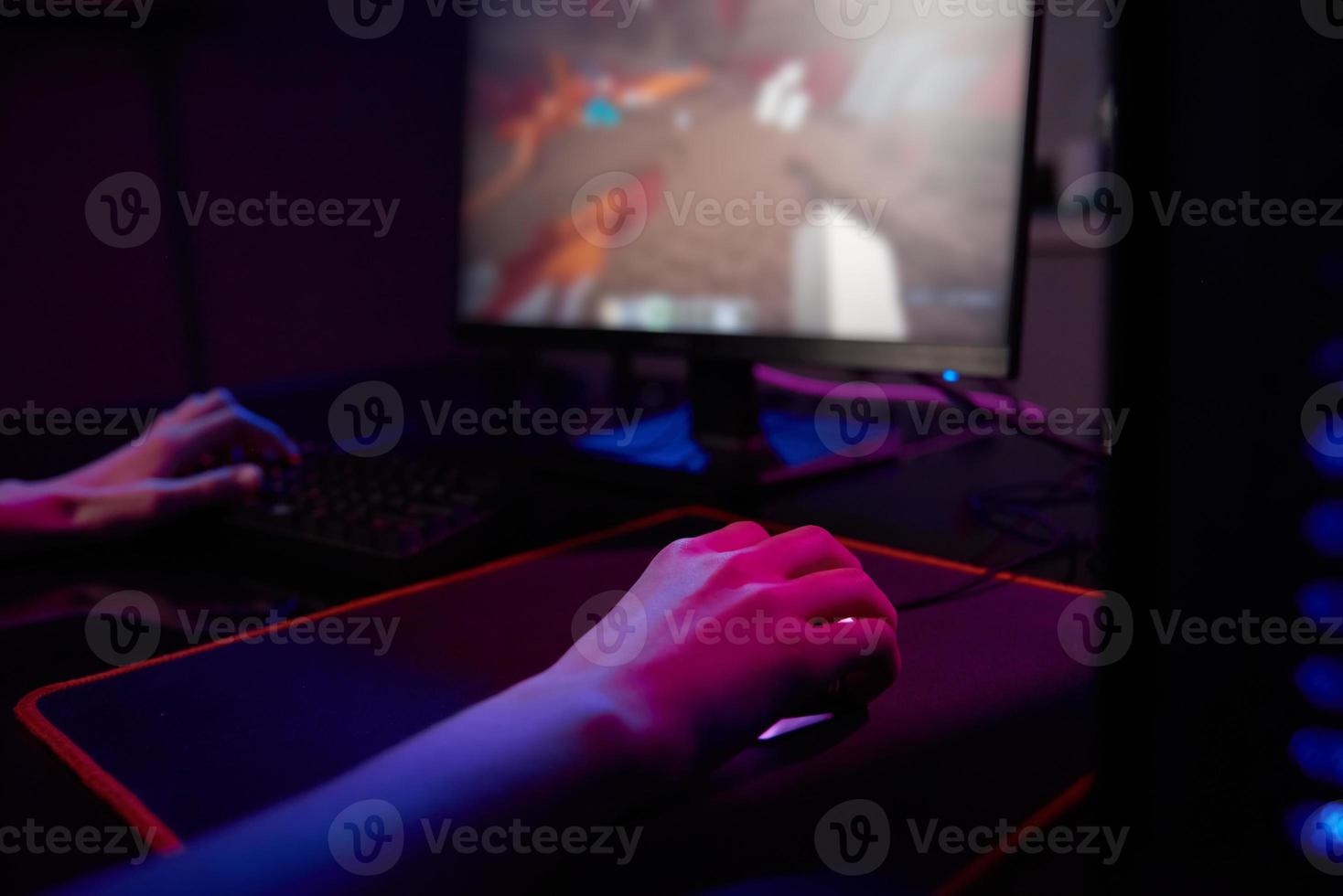 Gamer play computer game, use rgb neon colored keyboard photo