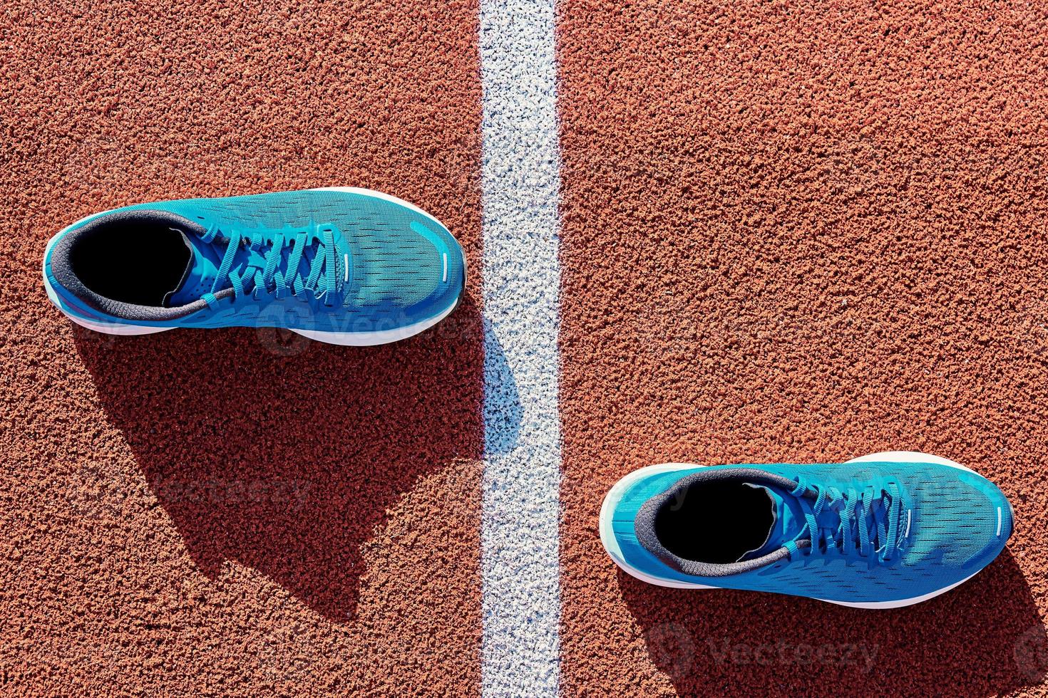 Blue running sneakers at stadium track photo