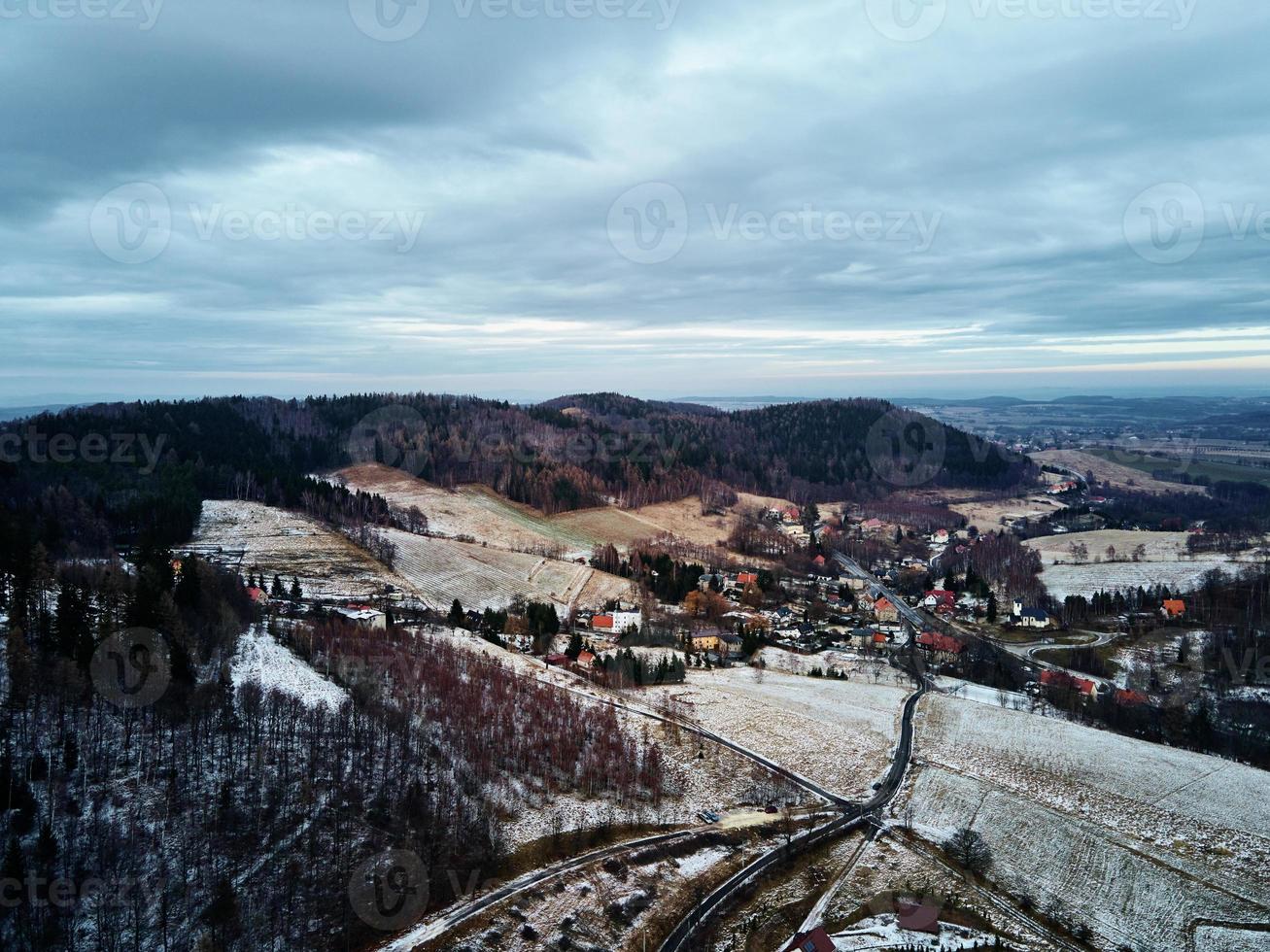 paisaje invernal con mvillage cerca de las montañas foto