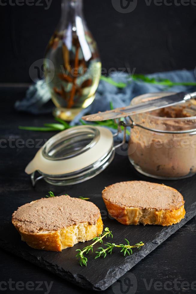 Sandwich with chicken liver pate on dark background photo