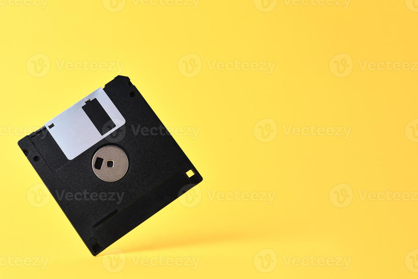 Floppy disk on yellow background photo