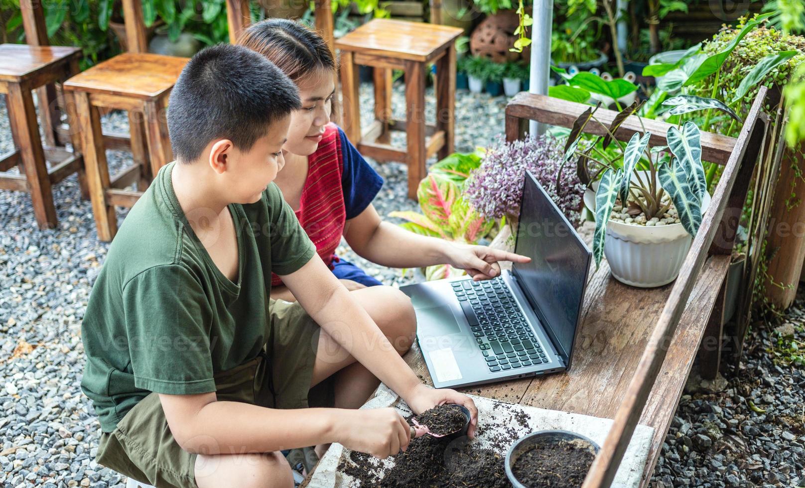 Portrait of a mother and son  special moment. Gardening discovering and teaching learns to grow flowers in pots through online teaching leisure activity concept photo