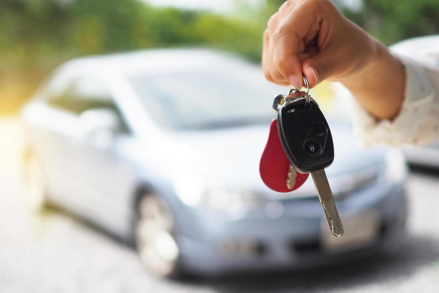The car owner is standing the car keys to the buyer. Used car sales photo