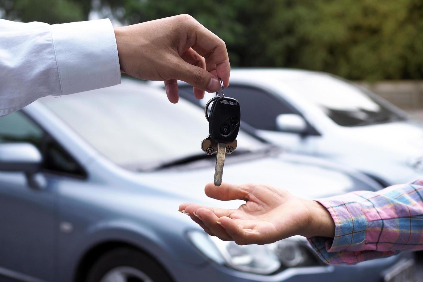 The car salesman and the key to the new owner. photo
