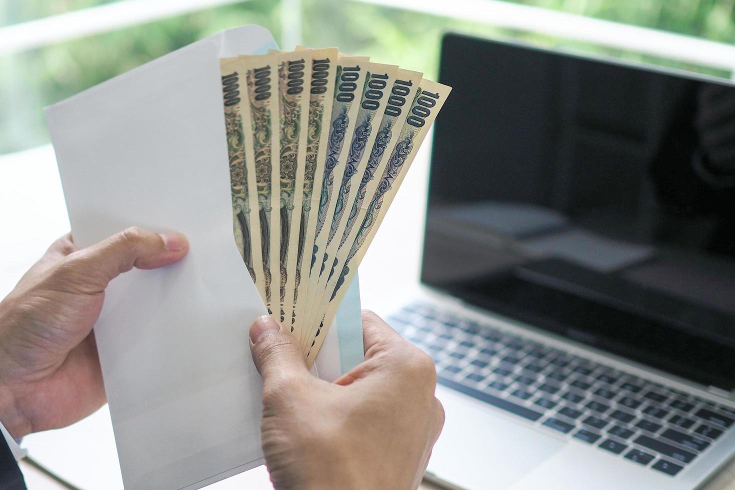 los hombres de negocios cuentan el yen japonés en un sobre. para preparar salarios o dinero de bonificación para los empleados de la empresa. foto