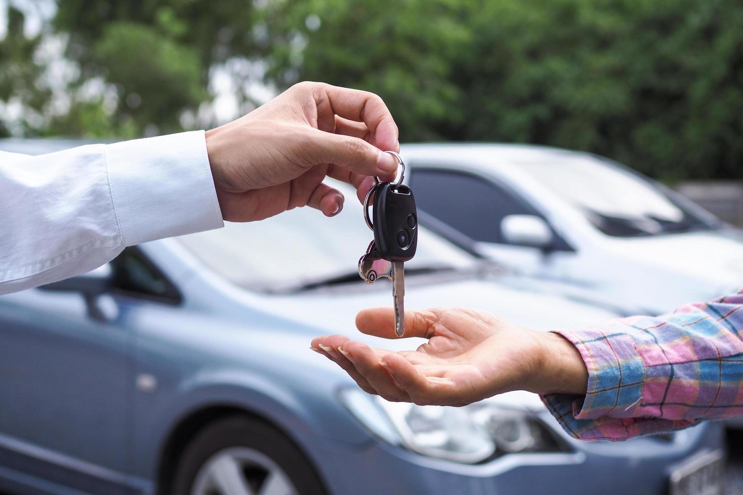 The car salesman and the key to the new owner. photo