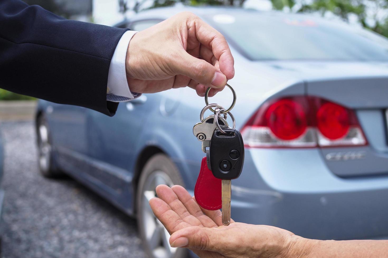 The car salesman and the key to the new owner. photo