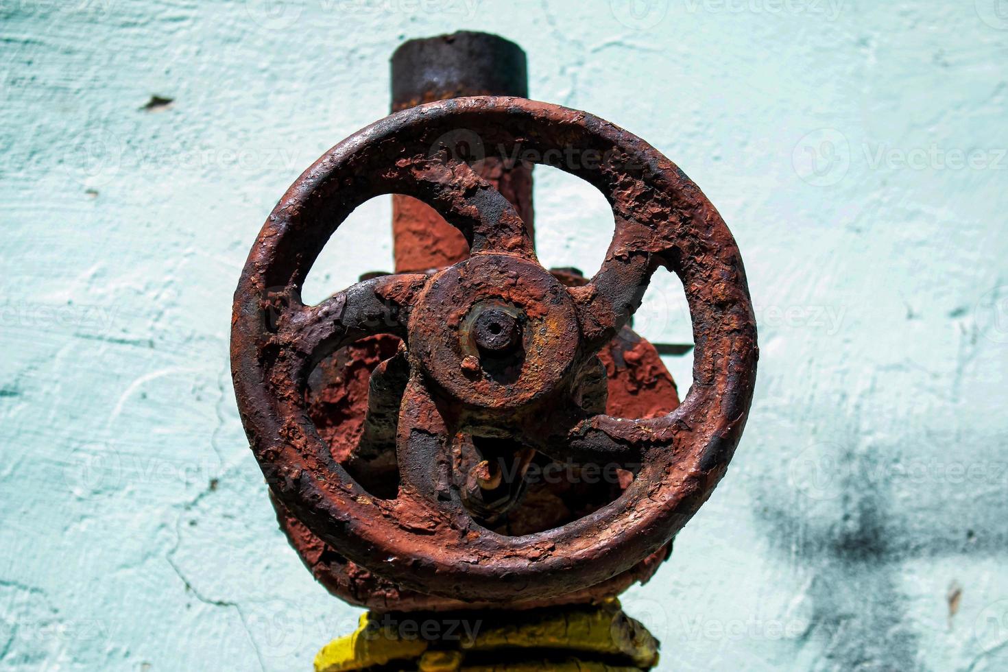 Rusty old gas tap on the background of the wall of the house. photo