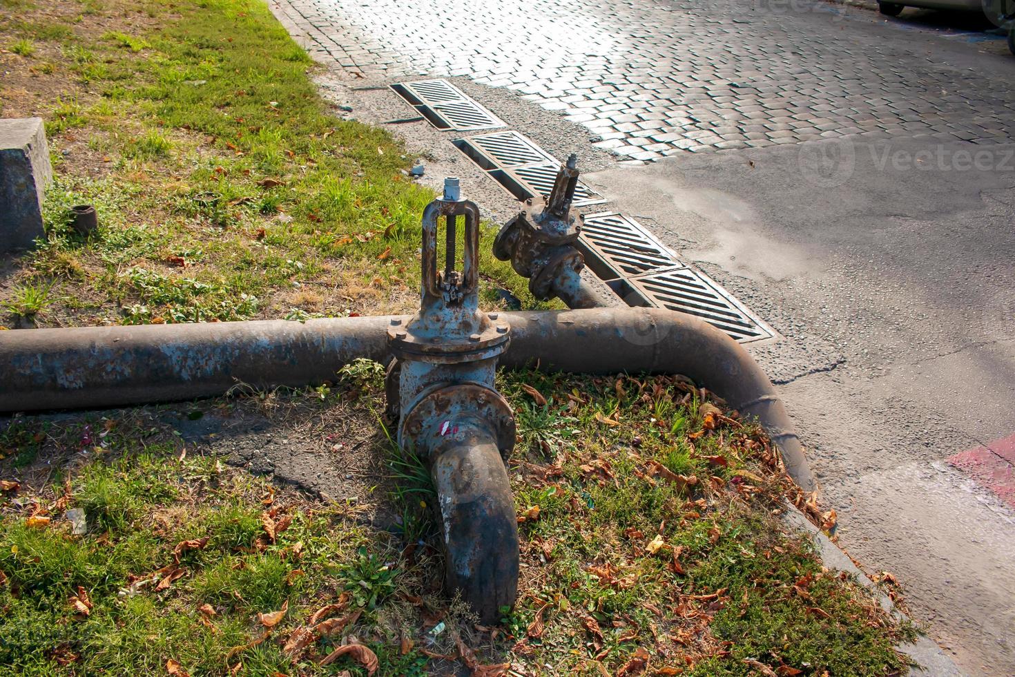 Rusty old water faucet on the background and tubes of water supply. photo