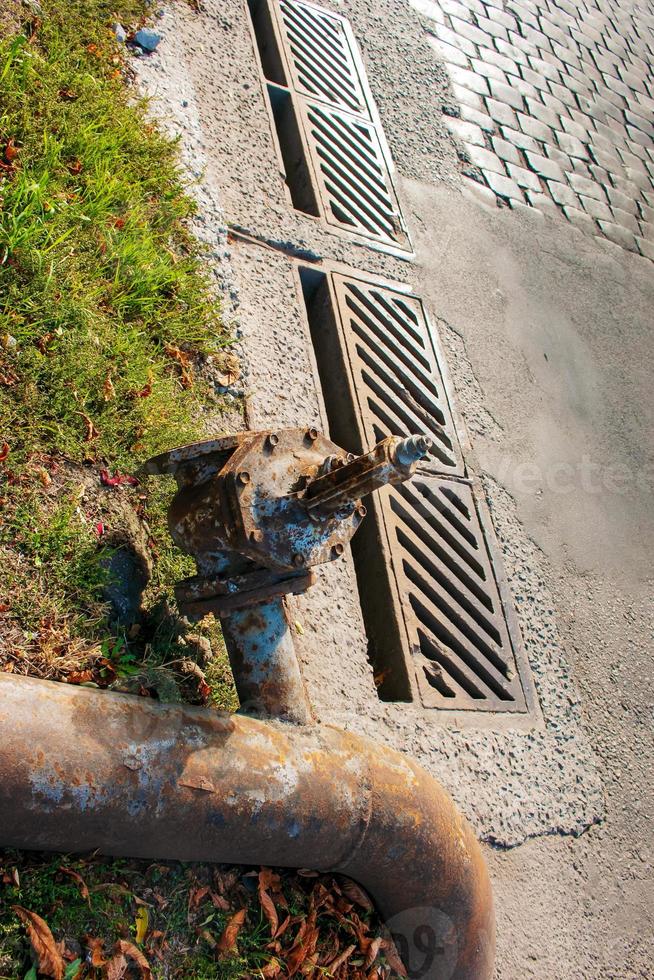 grifo de agua viejo y oxidado en el fondo y tubos de suministro de agua. foto