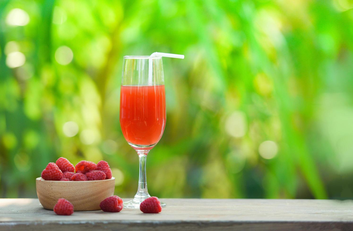 Summer juice glass raspberry cocktail and fresh raspberries fruit on wooden bowl photo