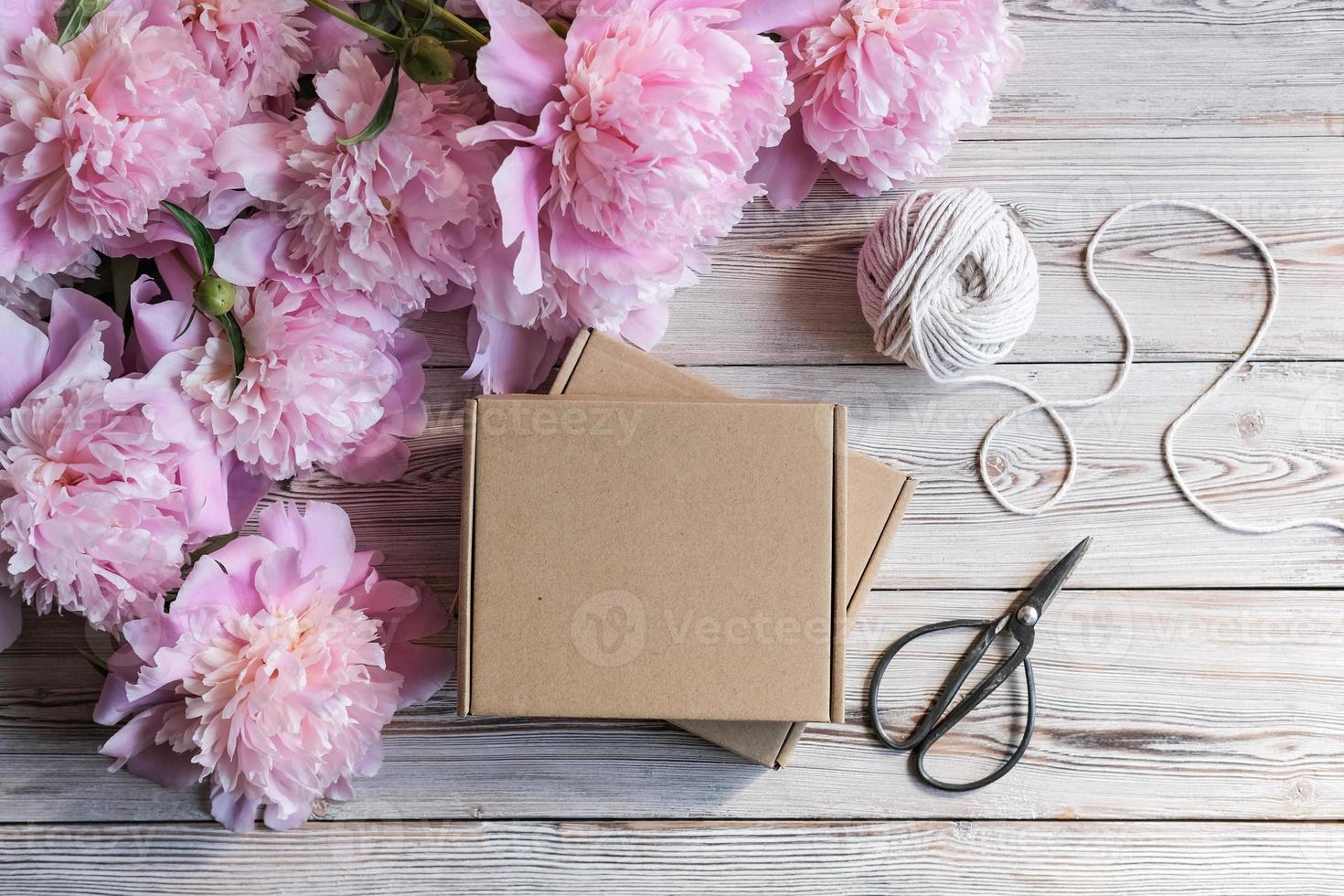 Brown cardboard boxes and a bouquet of peonies. Package box for branding. Mock up gift boxes photo