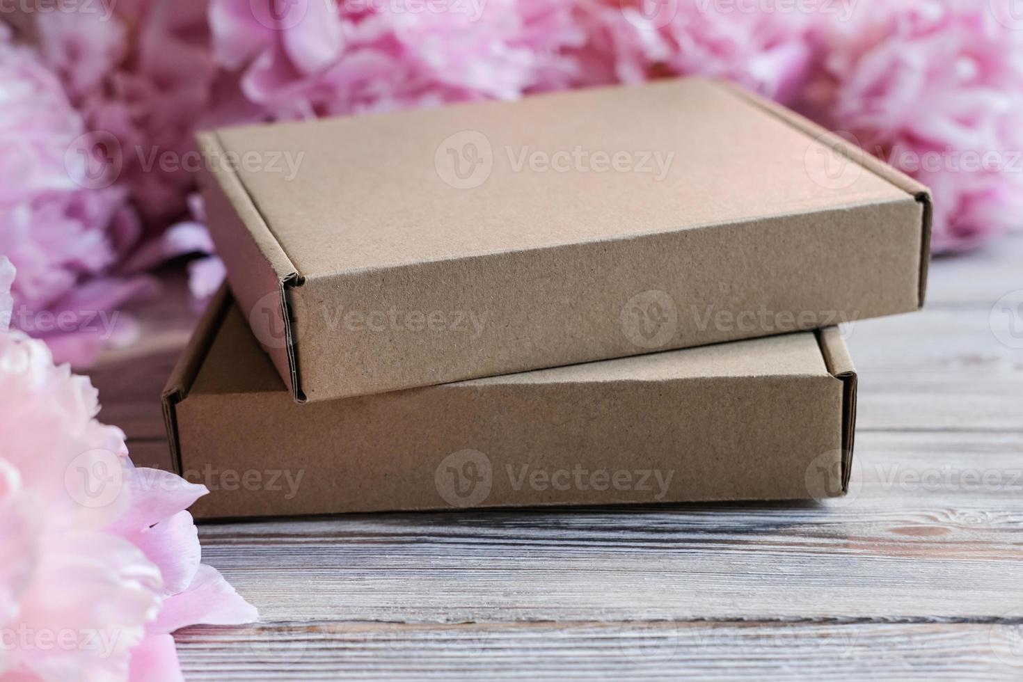 Brown cardboard boxes and peony flowers. Package box for branding. Mock up gift boxes photo
