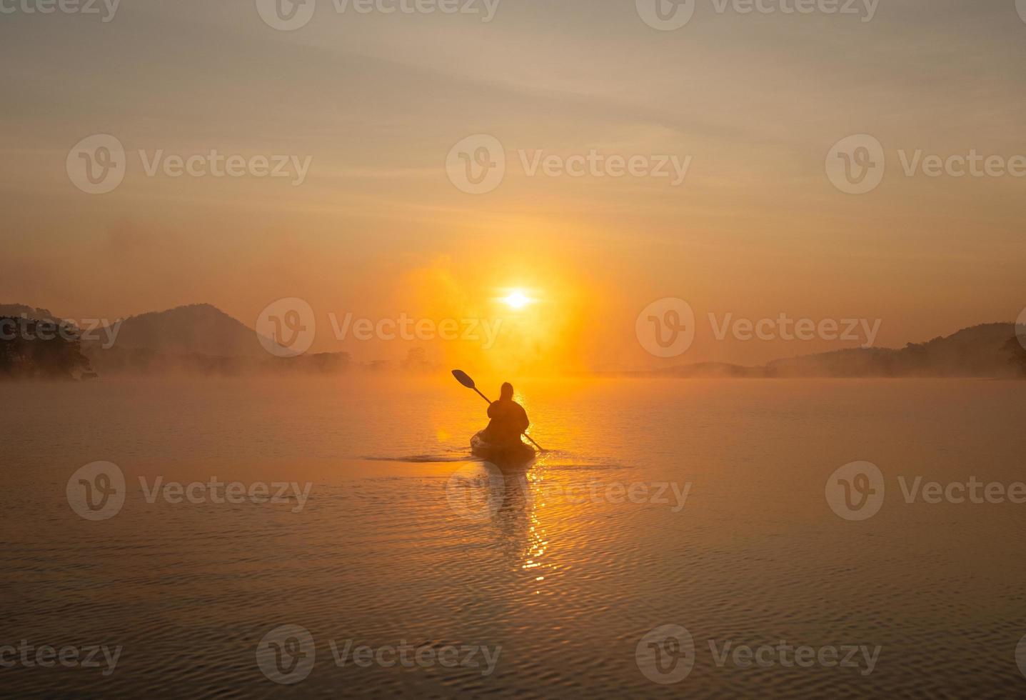 Women on kayak rows in the reservoir during the sunrise, Harirak forest park Huai Nam Man reservoir Loei Thailand 21 Jan 2023 photo
