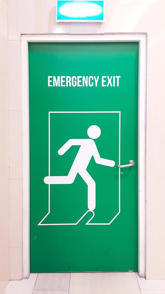 A green emergency exit door in the shopping mall building. Portrait. photo