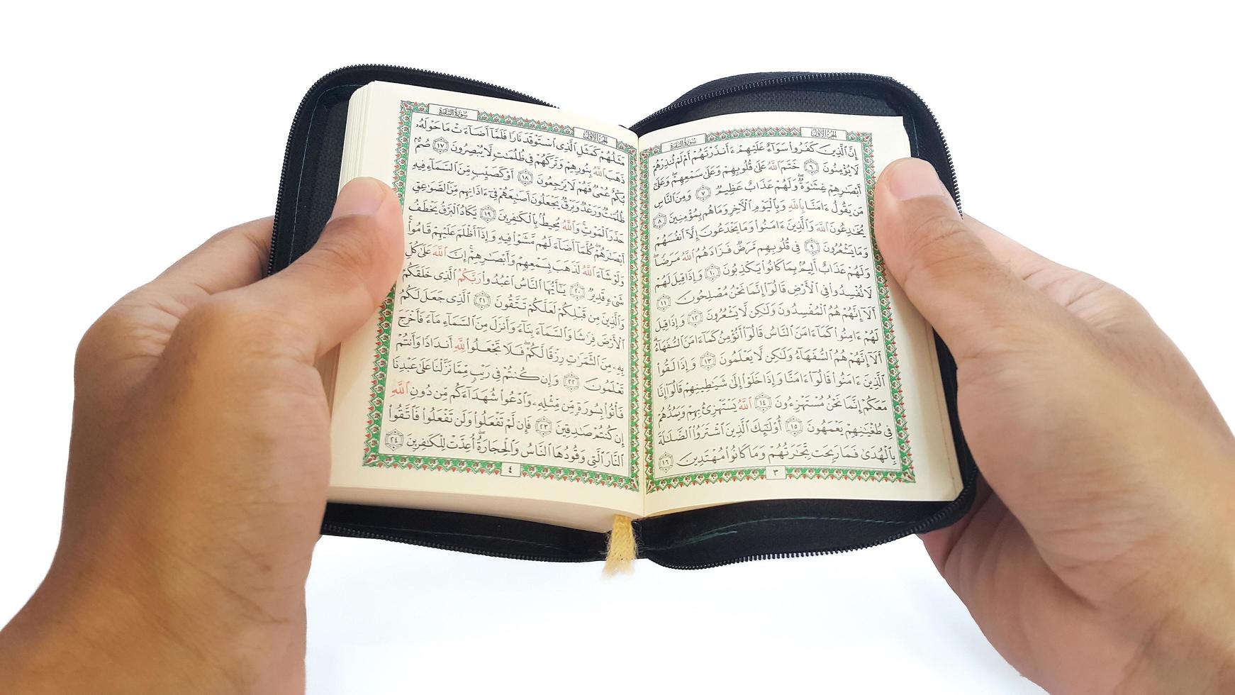 Man reading the holy quran. Hand holding a Holy Quran on white background. photo