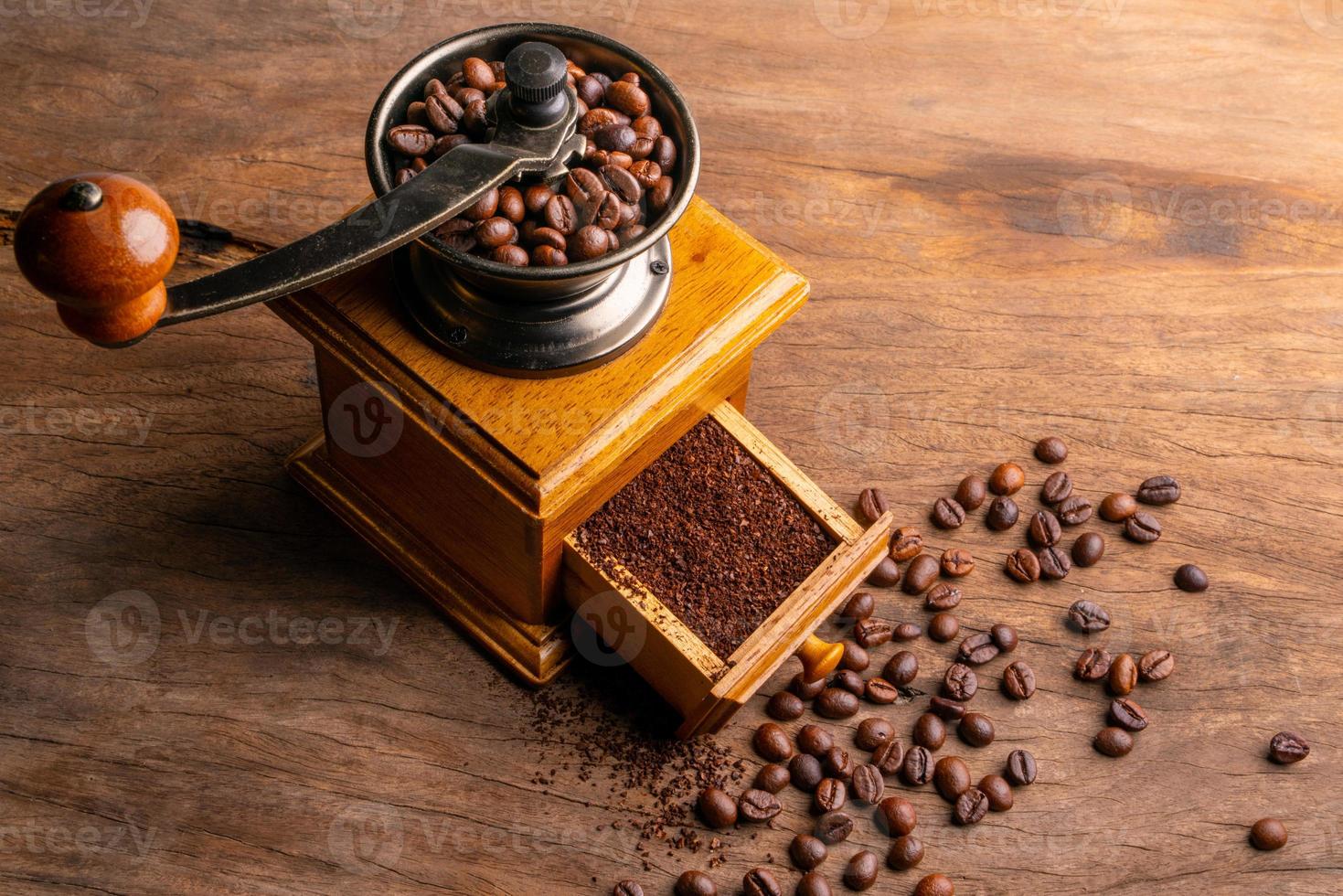 Vintage coffee grinder.Old retro hand-operated wooden and metal coffee grinder.Manual coffee grinder for grinding coffee beans on an old wooden background.selective focus, soft focus. photo