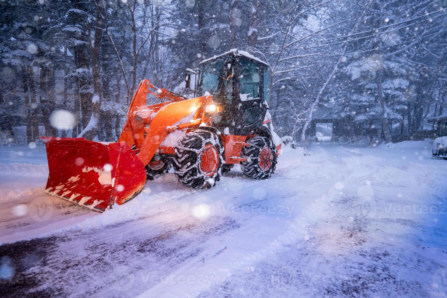 tractor de pala de nieve en un día de mucha nieve en el pueblo de heike no sato en la prefectura de tochigi, ciudad de nikko, japón. enfoque suave. foto