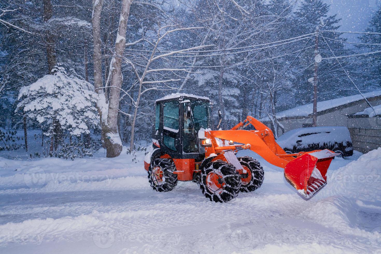 tractor de pala de nieve en un día de mucha nieve en el pueblo de heike no sato en la prefectura de tochigi, ciudad de nikko, japón. enfoque suave. foto