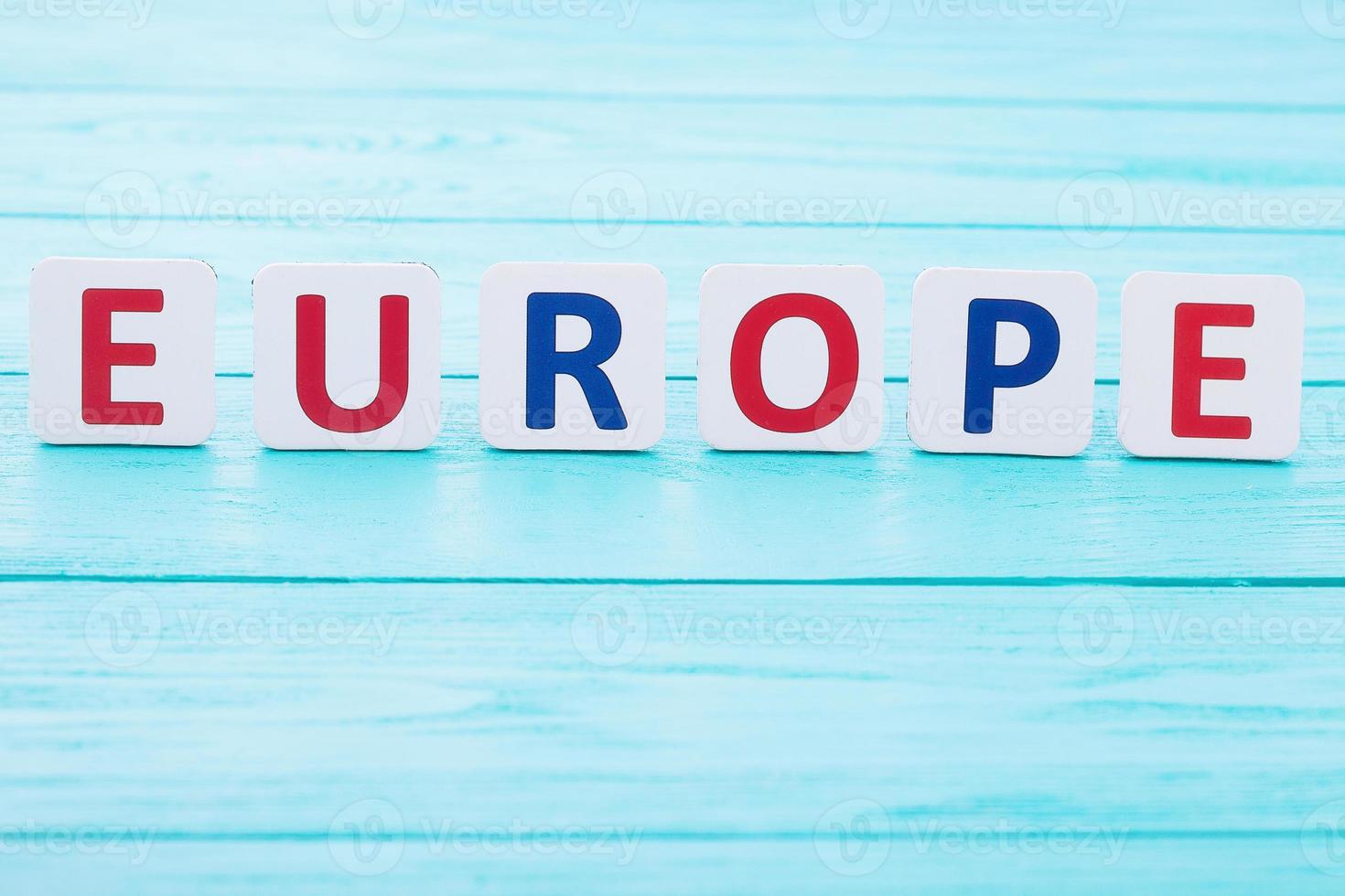 Word Europe on blue wooden background. Copy space and selective focus photo