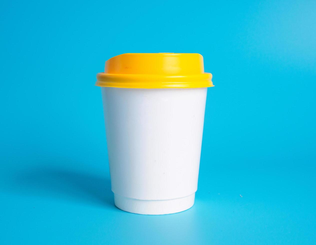 White coffee cup top view photograph On a white saucer The inside of the glass looks empty. Waiting for hot coffee to be refilled to drink to feel refreshed and alert on a blue background. photo