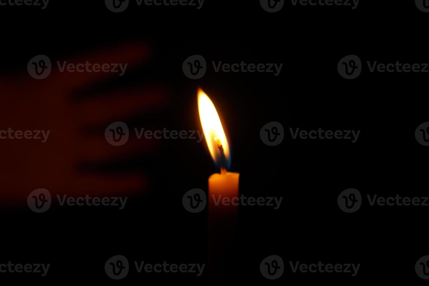 Human hands protect candlelight at night that illuminates things. photo