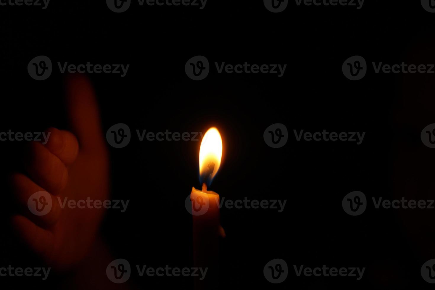 Human hands protect candlelight at night that illuminates things. photo