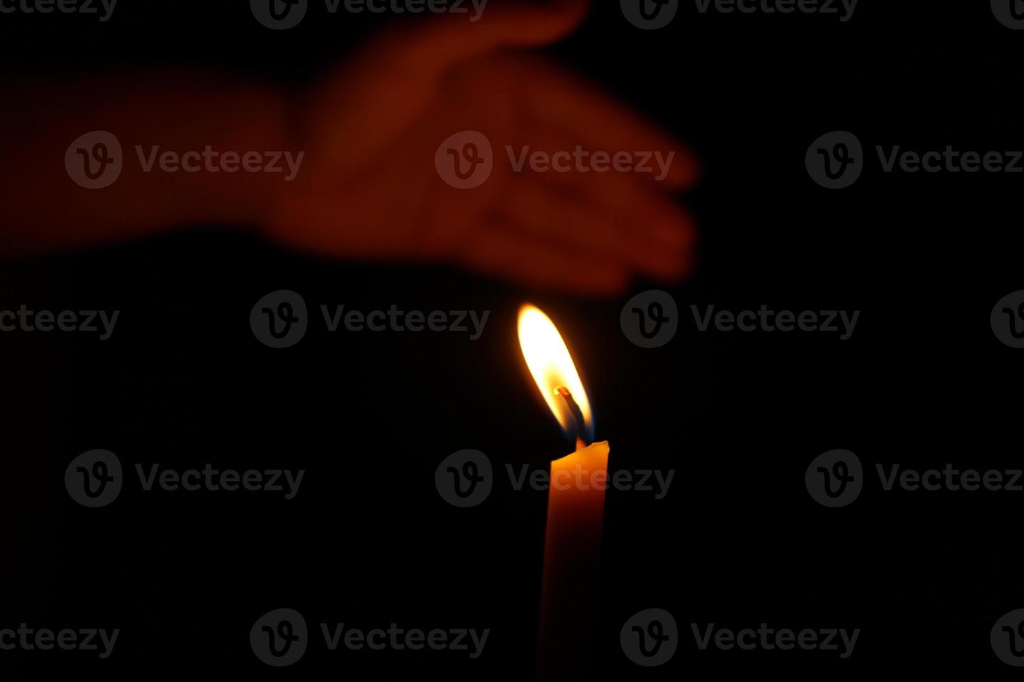 Human hands protect candlelight at night that illuminates things. photo