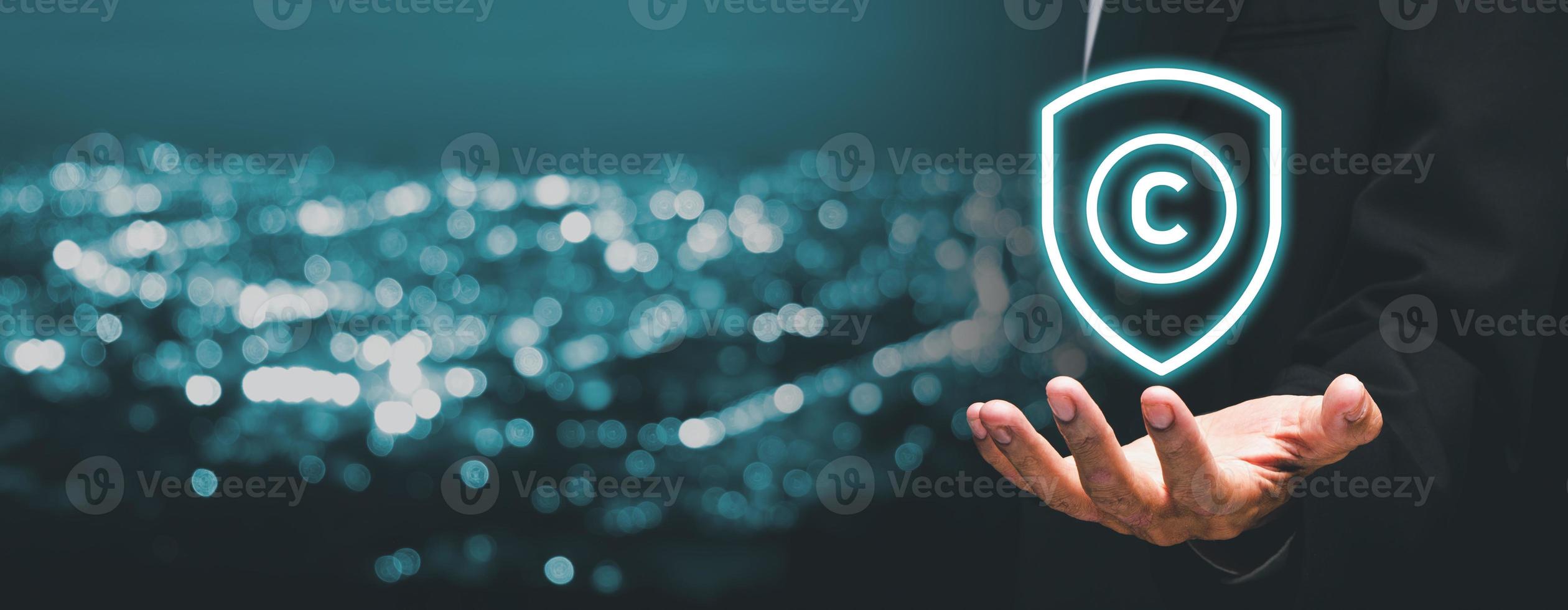 Copyright or patent concept, Business person hand holding VR screen copyright icon with blue bokeh background, Copyleft trademark license, Creation ownership against piracy crime photo