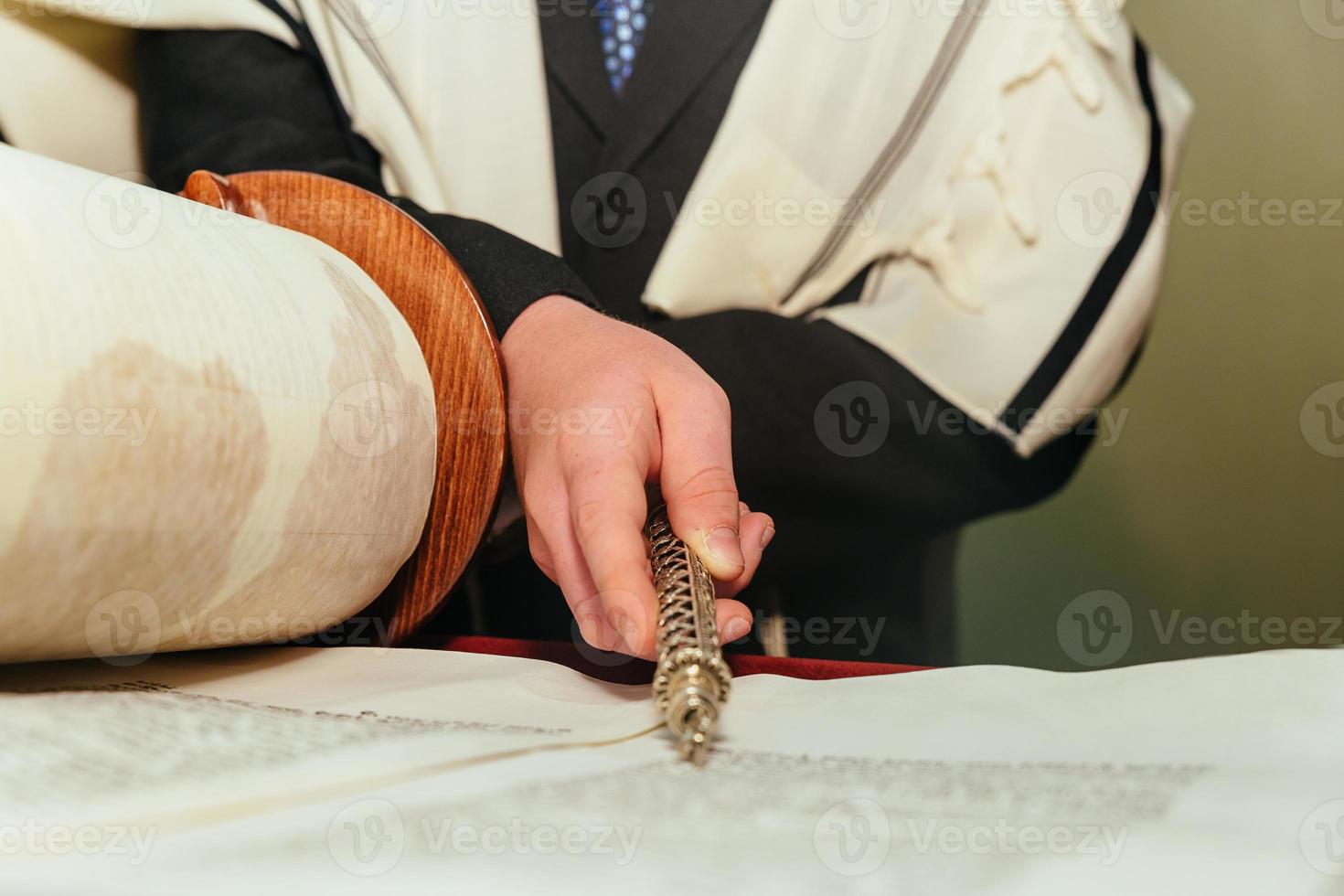 Hand of boy reading the Jewish Torah at Bar Mitzvah photo