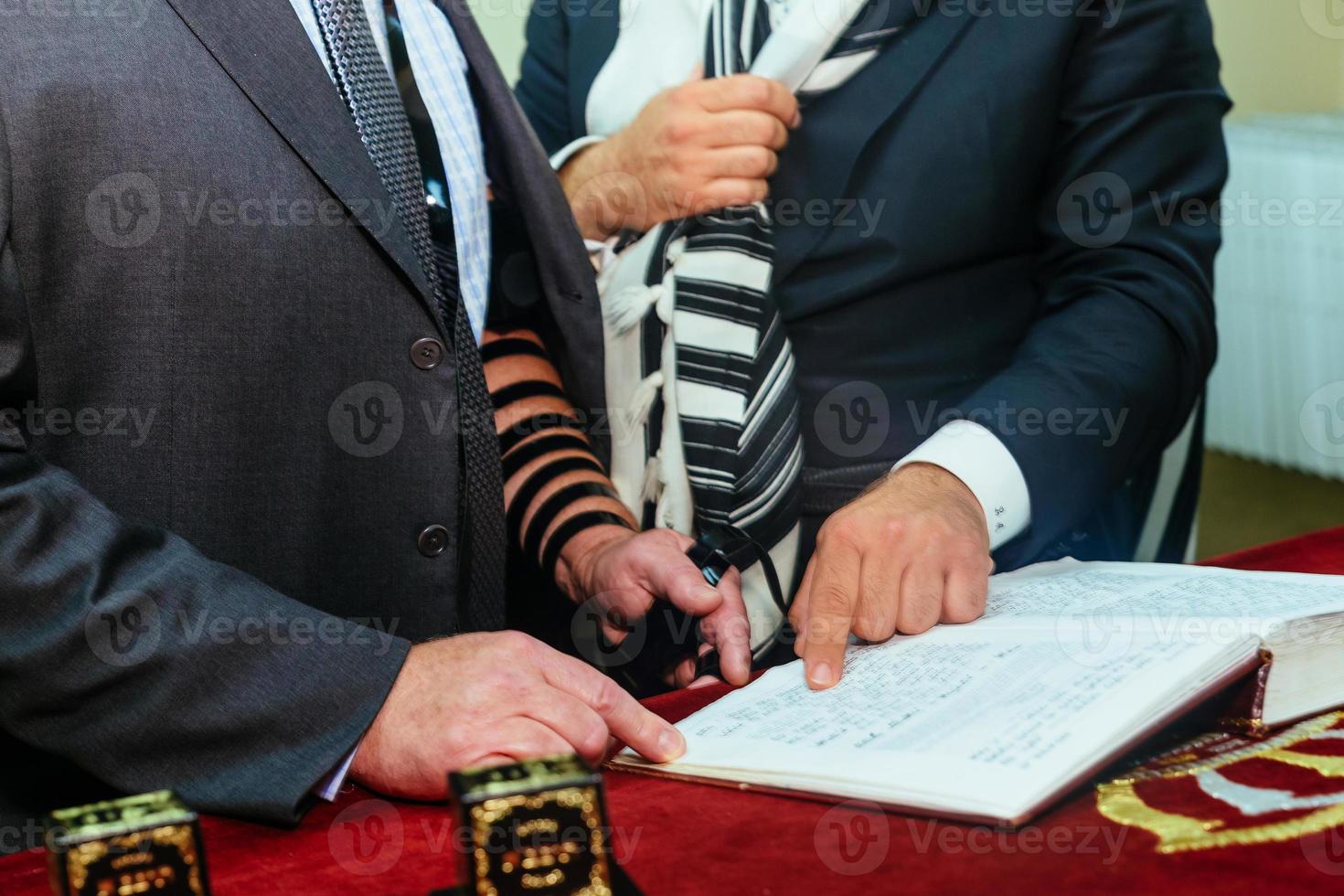 Hand of boy reading the Jewish Torah at Bar Mitzvah photo